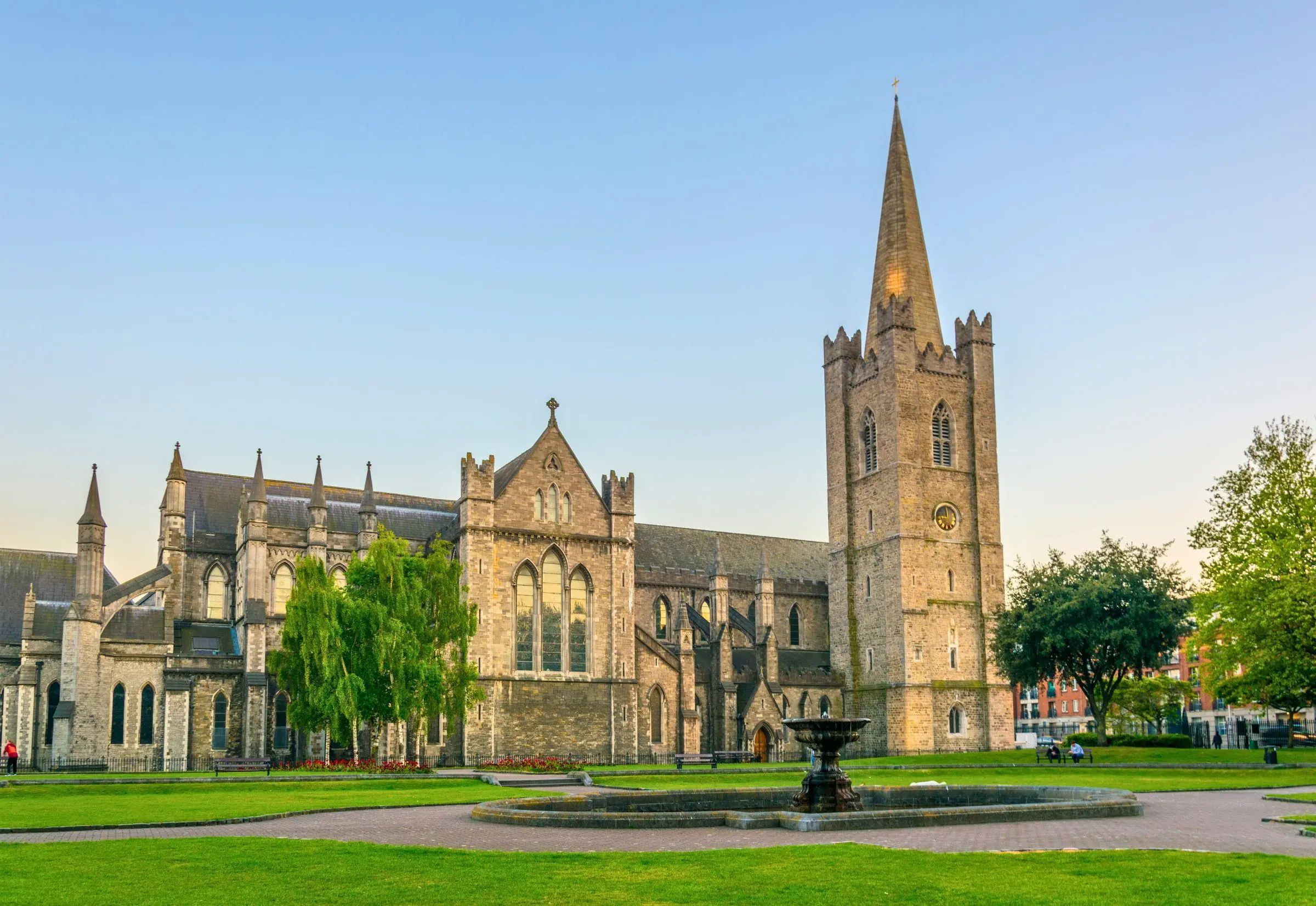 Exterior view of St Patrick's Cathedral in Dublin surrounded by green parkland